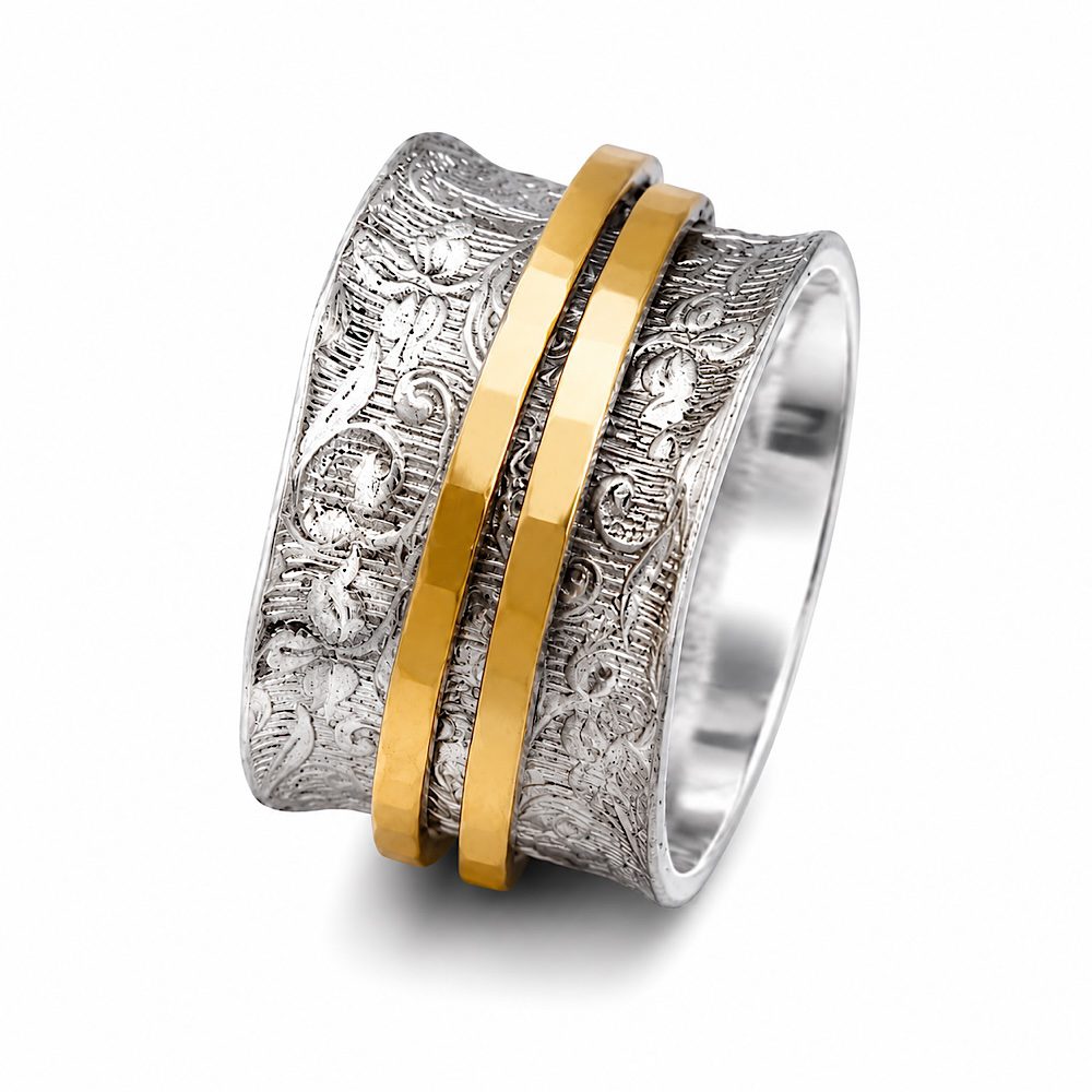 Handcrafted sterling silver spinner ring featuring an engraved floral wide band with two hammered yellow gold spinning rings. Made in London.