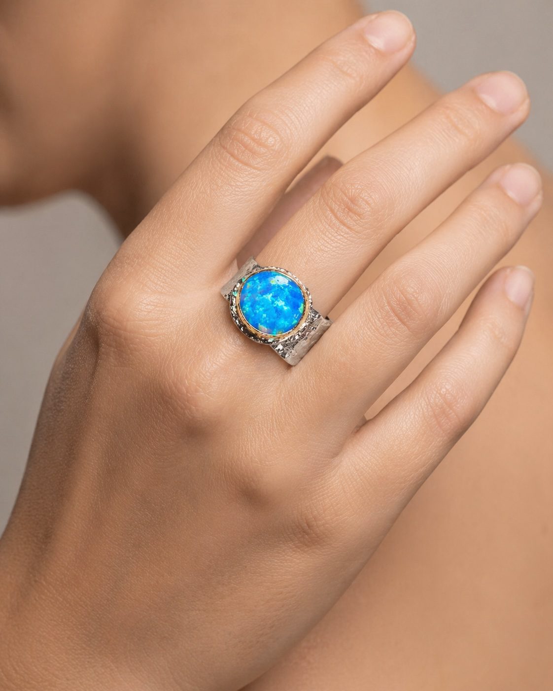 Model wearing handcrafted silver and gold opal ring by Yaron Morhaim