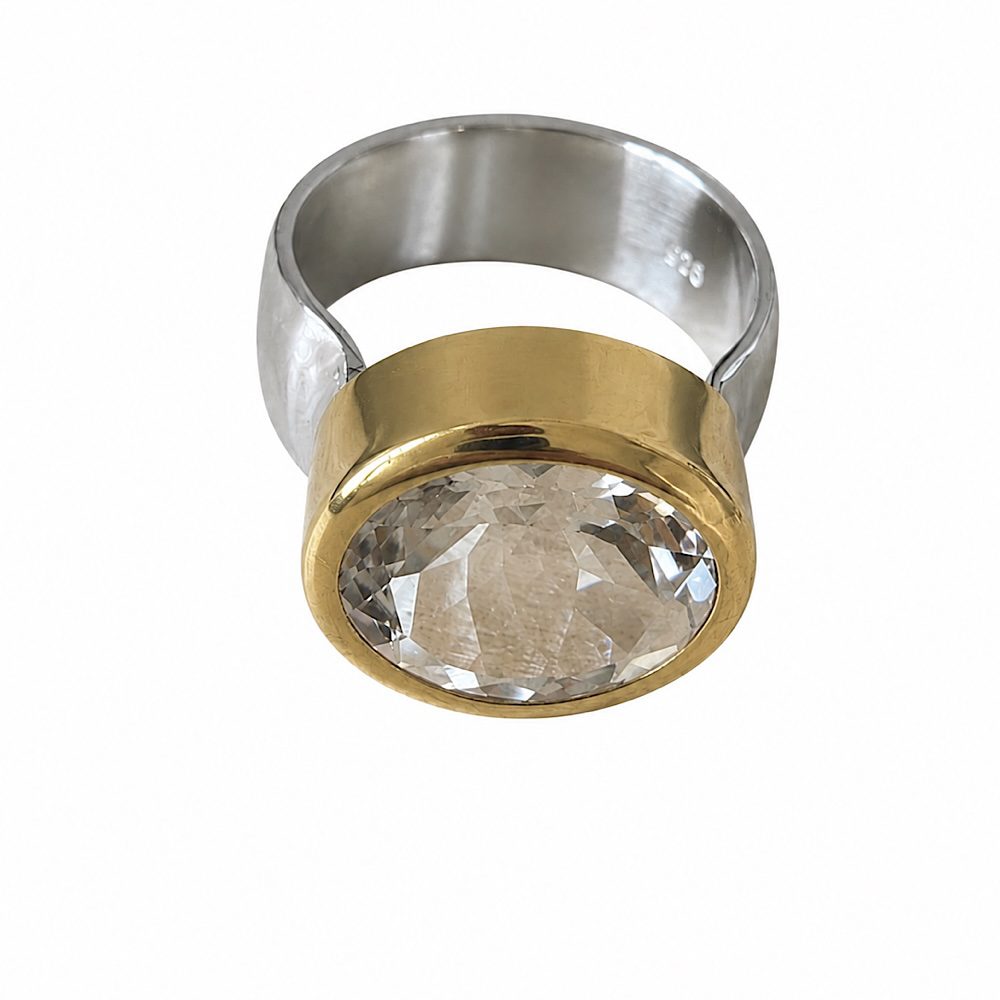 Handcrafted sterling silver and gold white topaz statement ring with large oval faceted gemstone on white background