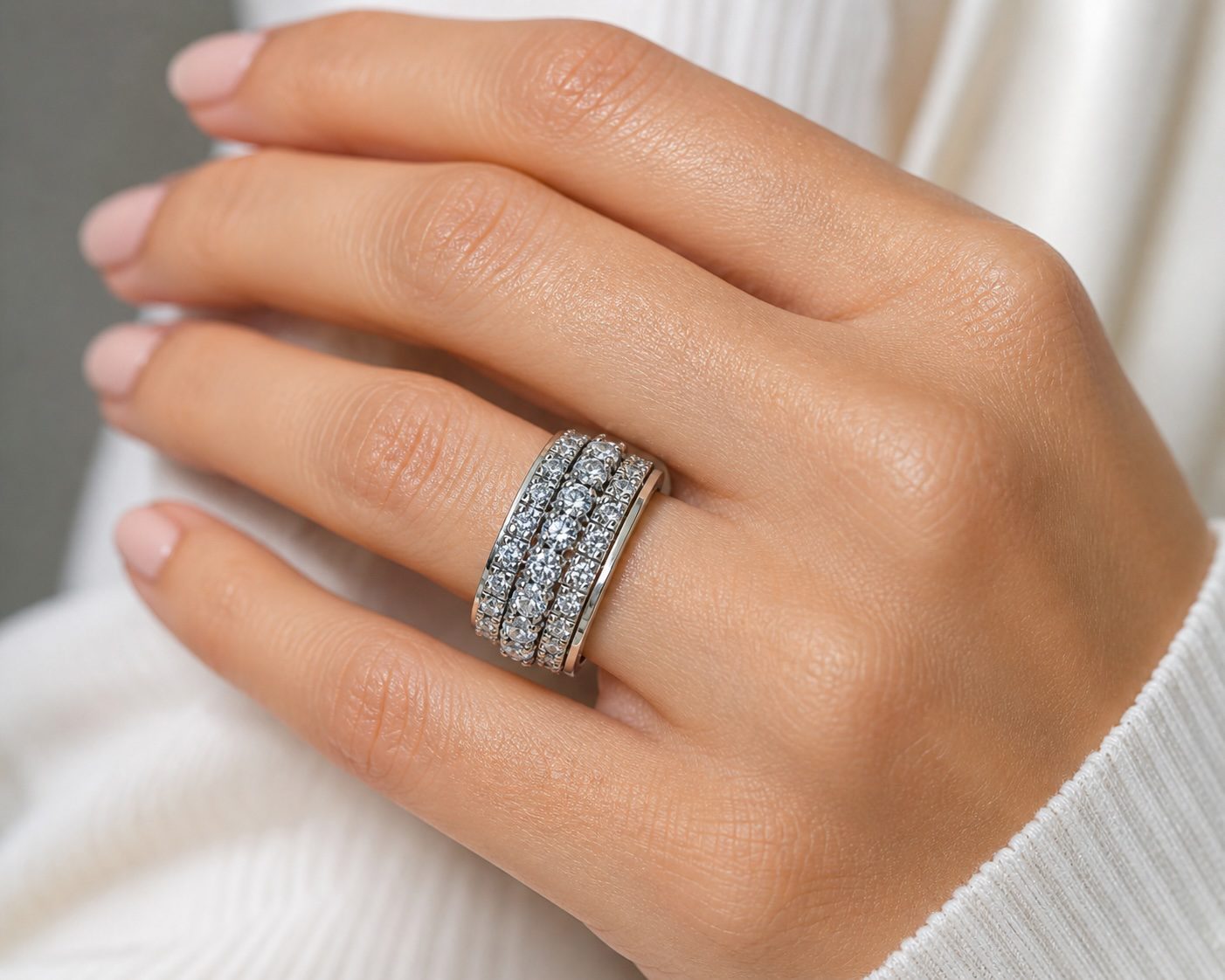 silver and gold spinning ring worn on hand showing rotating cubic zirconia band