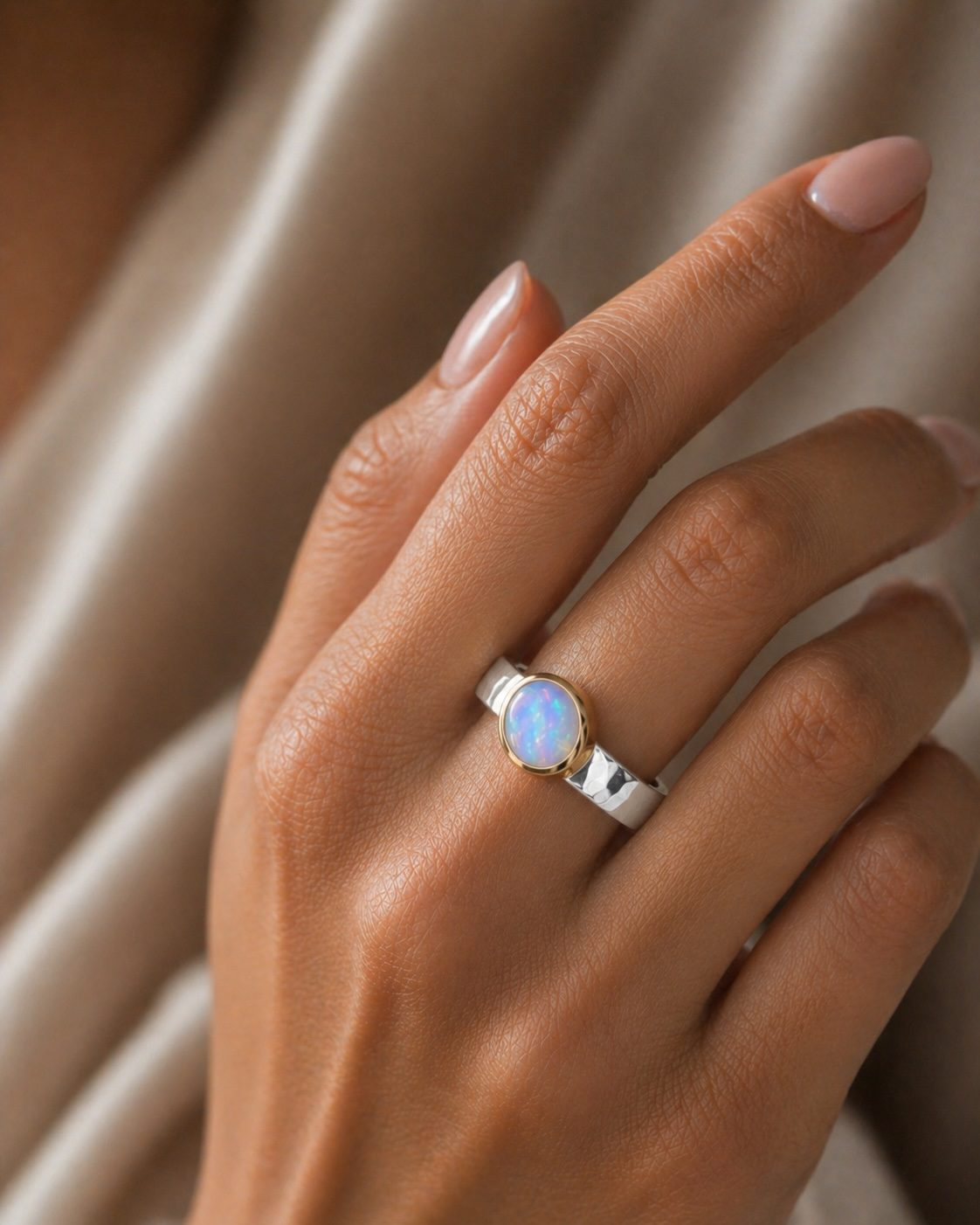 Oval white opal silver and gold ring on elegant model hand