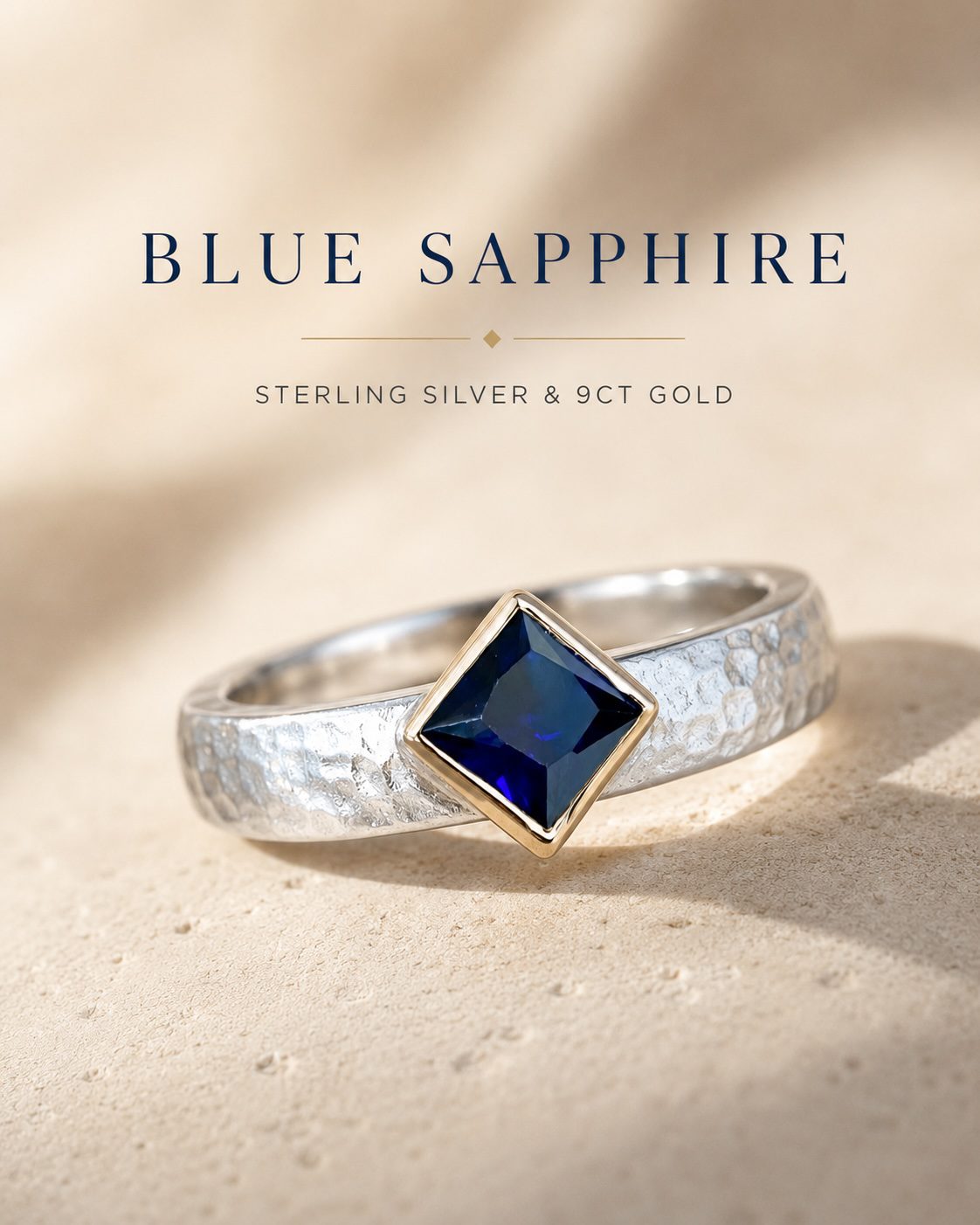 Artisan blue sapphire ring with a sterling silver band and 9-carat gold setting, showcasing a deep blue oval sapphire in an elegant luxury jewellery photograph.