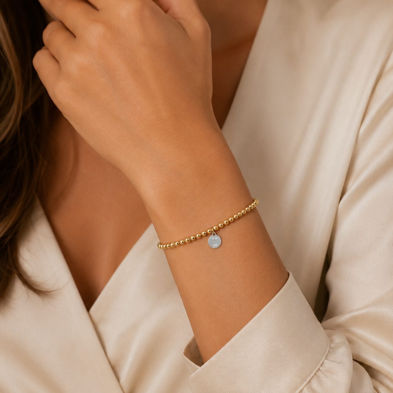 Polished gold sphere bracelet detail with handcrafted clasp fastening