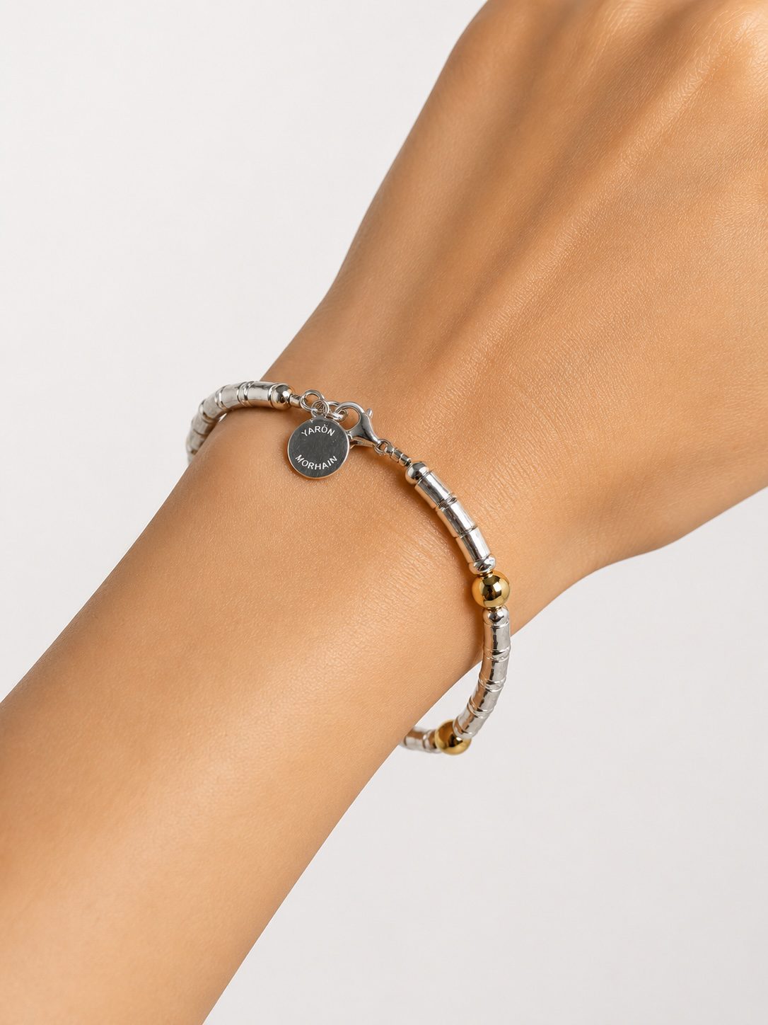 Woman wearing handcrafted silver and gold beaded bracelet by Yaron Morhaim